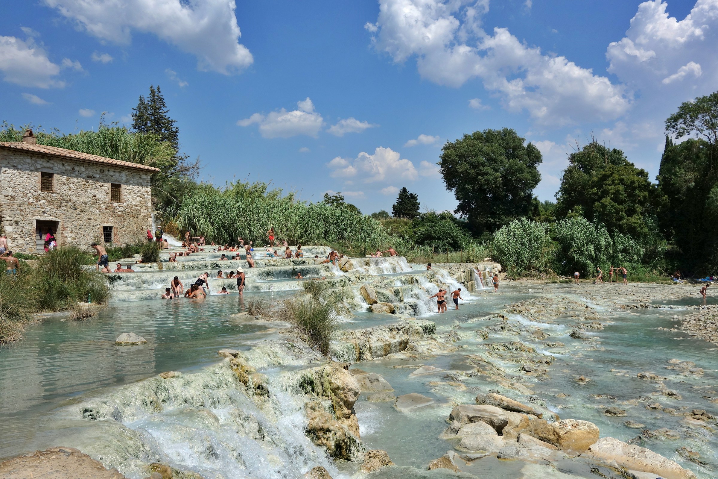 Bathers in the warm river pools beside the old stone mill at Saturnia