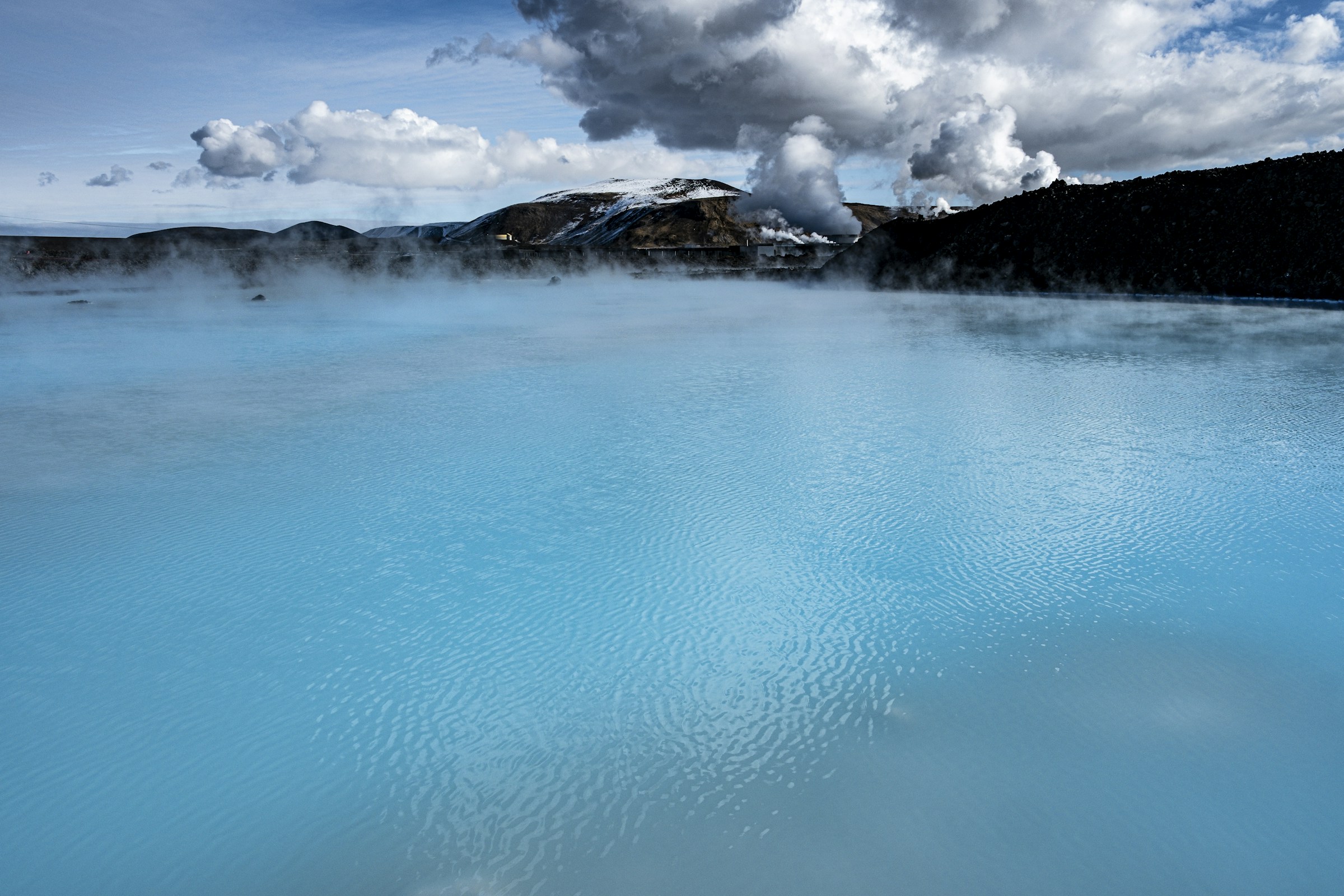 Steam drifting across the milk-blue water of the Blue Lagoon in Iceland